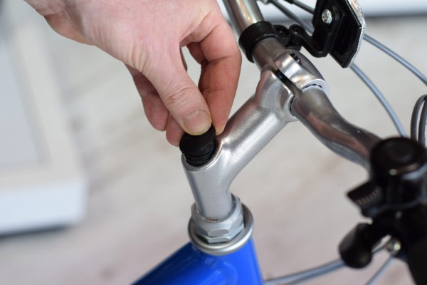 Carefully remove the plug covering the top stem bolt (if present) with your fingers or a flat head screwdriver
